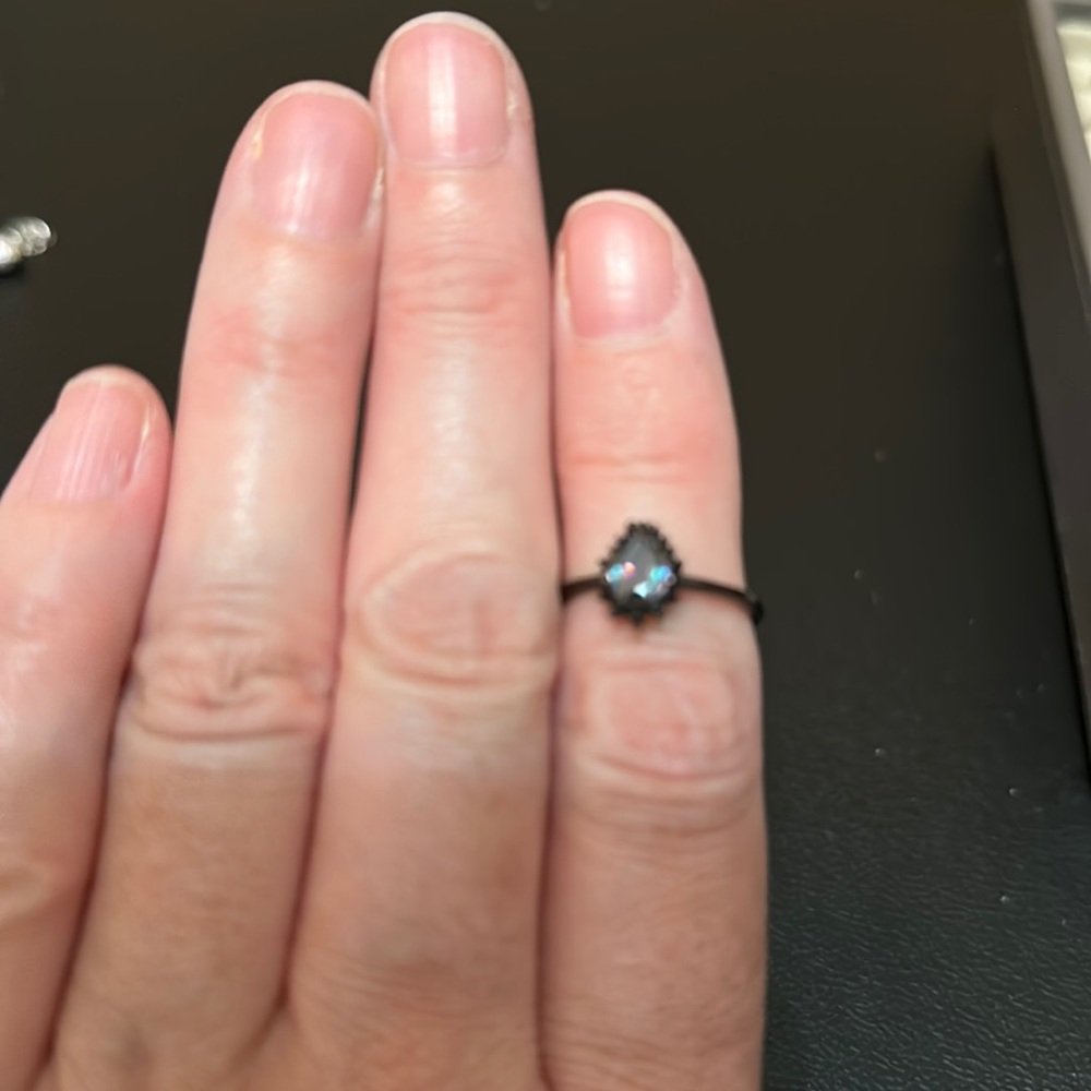 Purple, blue, green stone, black setting with black stone surrounding setting